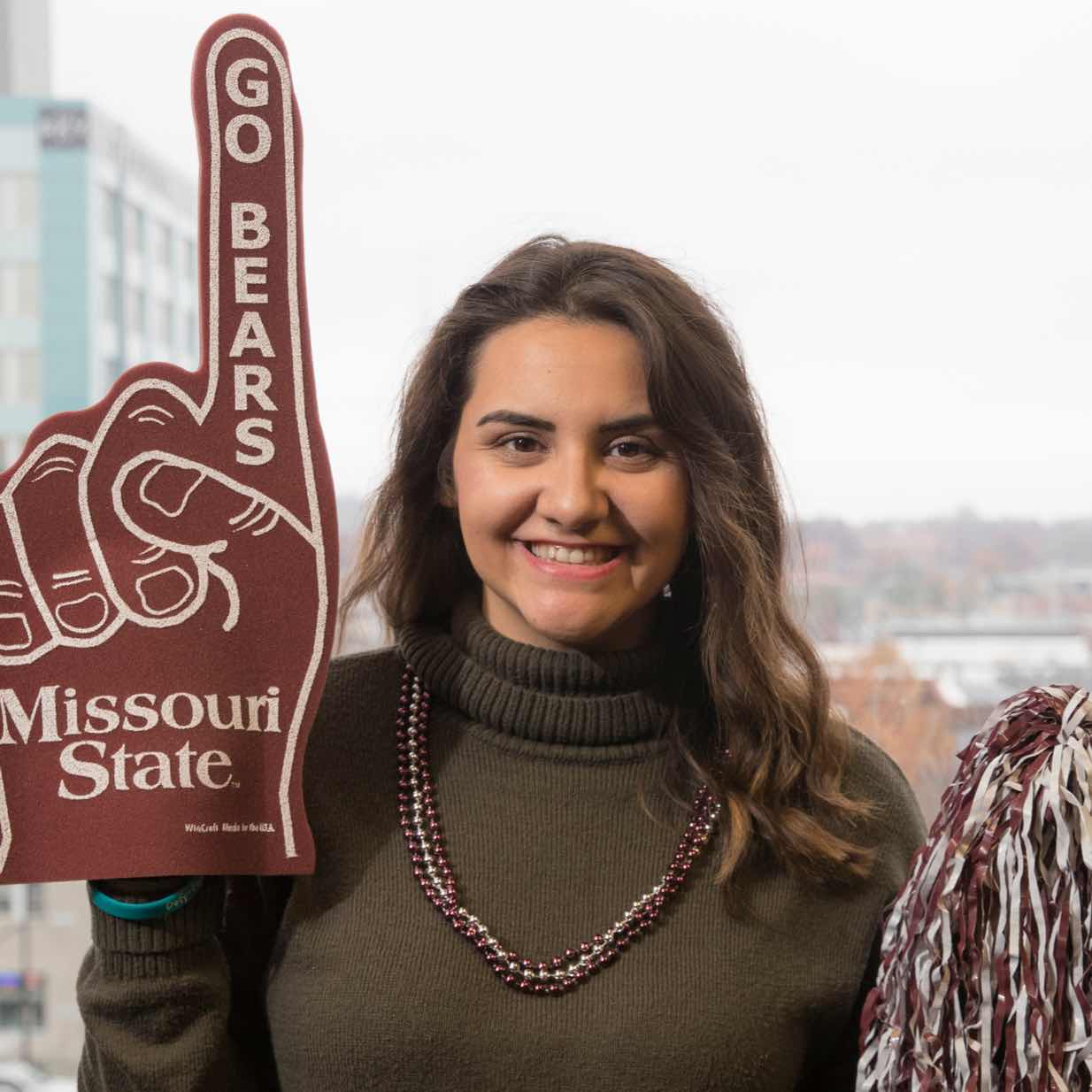 Woman wearing Missouri State Bears foam finger with urban background