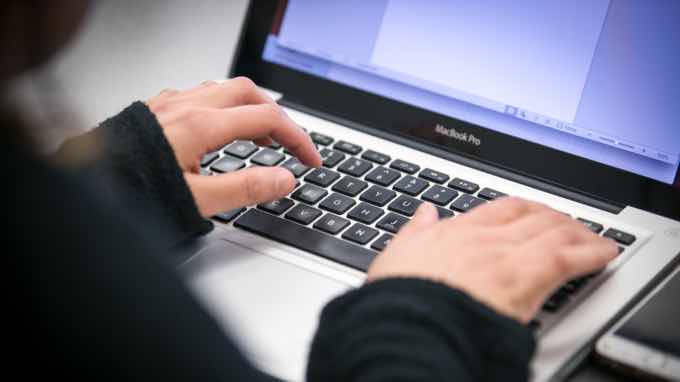 Close-up of hands on a laptop keyboard