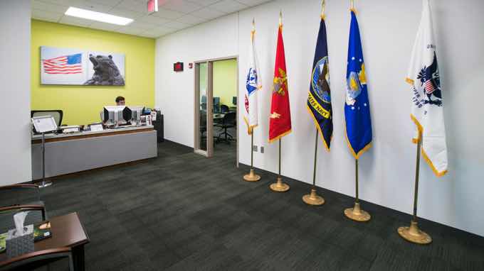 Office foyer with flags from each military branch
